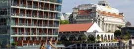 Cyclists on the Marina Bay waterfront in front of The Fullerton Hotel Singapore and The Fullerton Bay Hotel